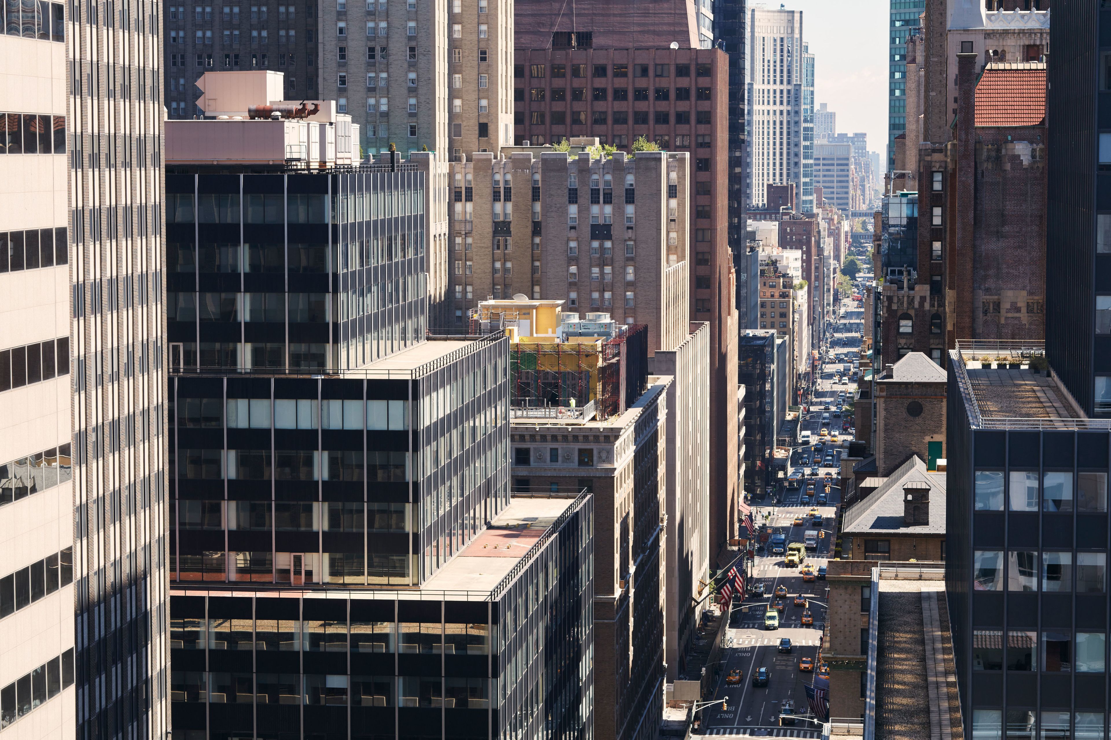 Un horizonte urbano con edificios altos, una calle concurrida y cielo despejado.