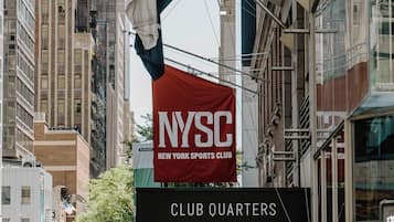 A street view with a NYSC New York Sports Club sign and a Club Quarters sign.
