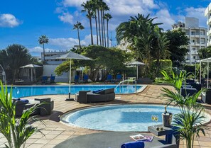 Relax by the pool surrounded by comfortable seating and lush greenery.
