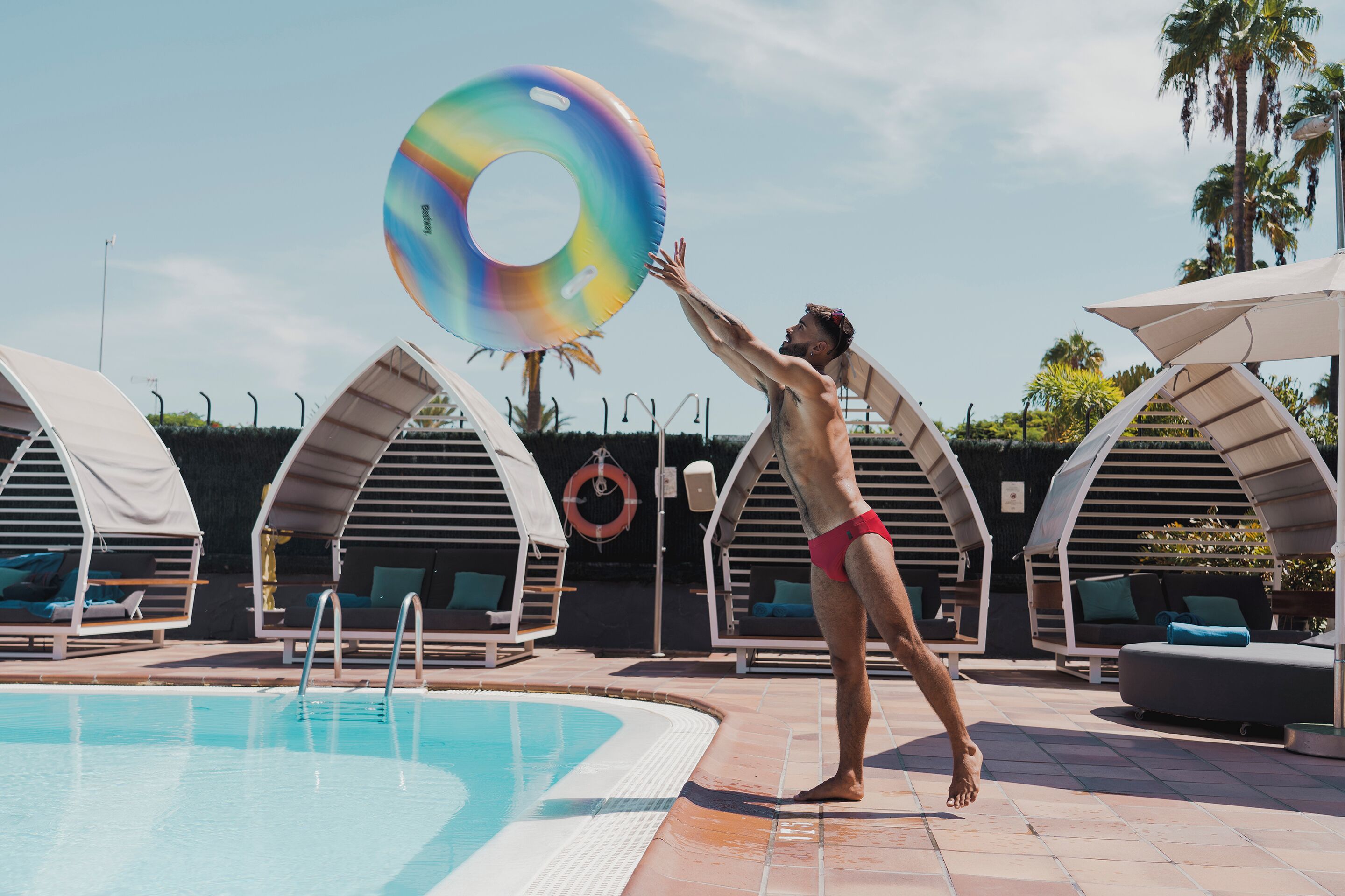 Un área de piscina con sillones de descanso y sombrillas.
