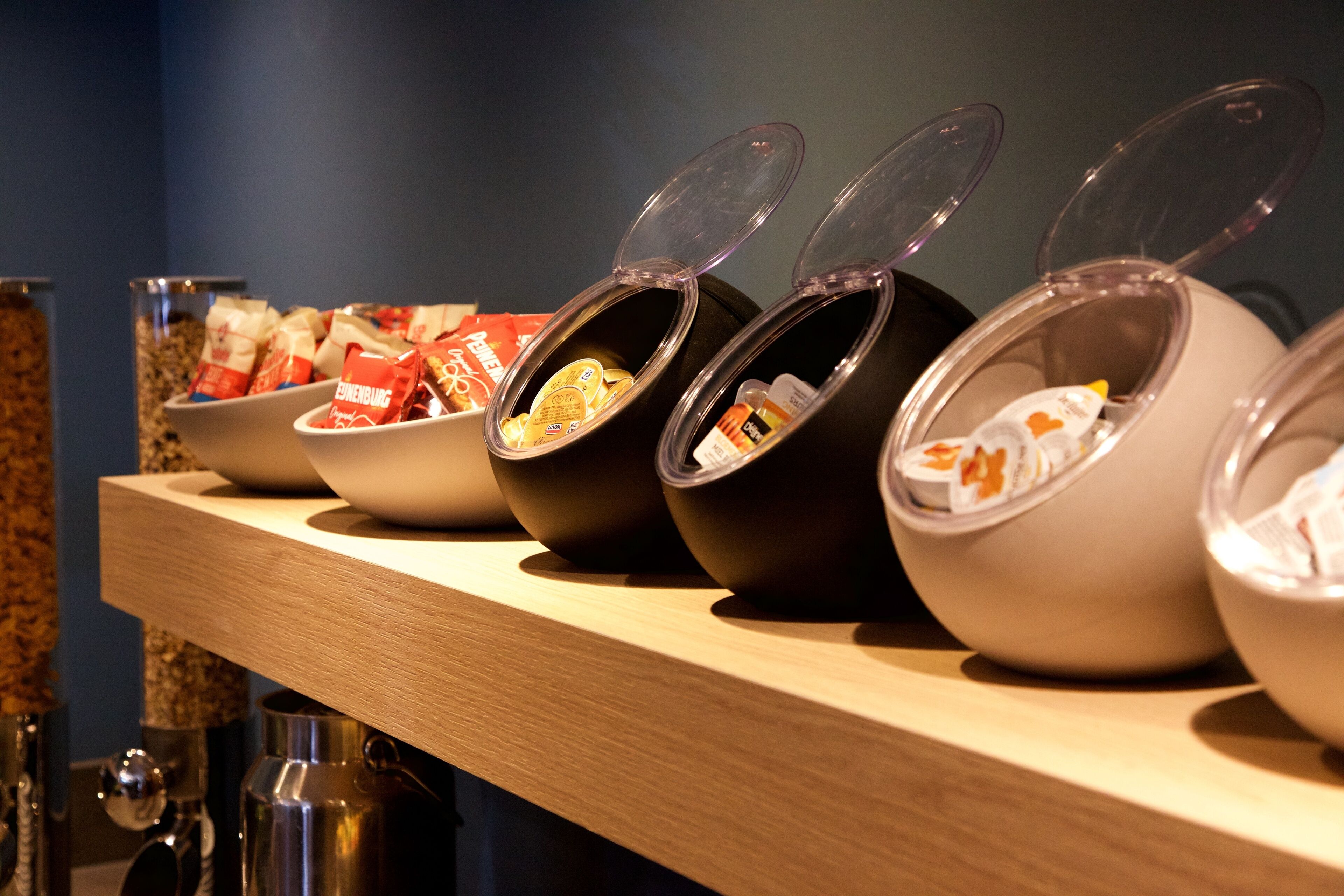 Una barra de buffet con distintos alimentos servidos en cuencos y recipientes.