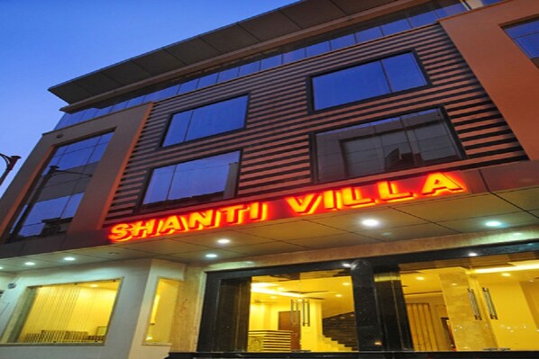 Un hotel moderno con un llamativo letrero que dice 'SHANTHI VILLA'.