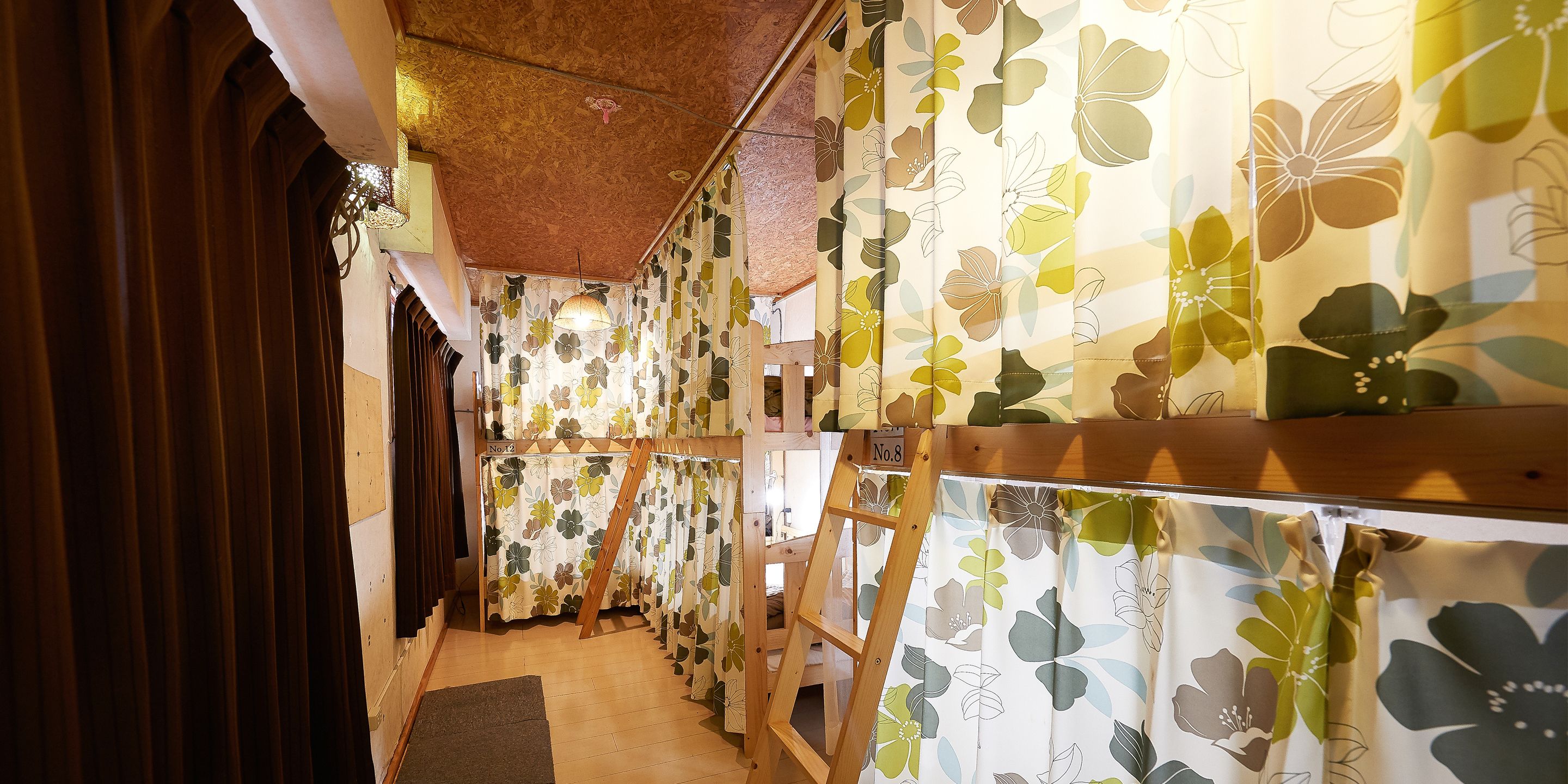 A narrow hallway with wooden slats on the left and floral-patterned curtains on the right.