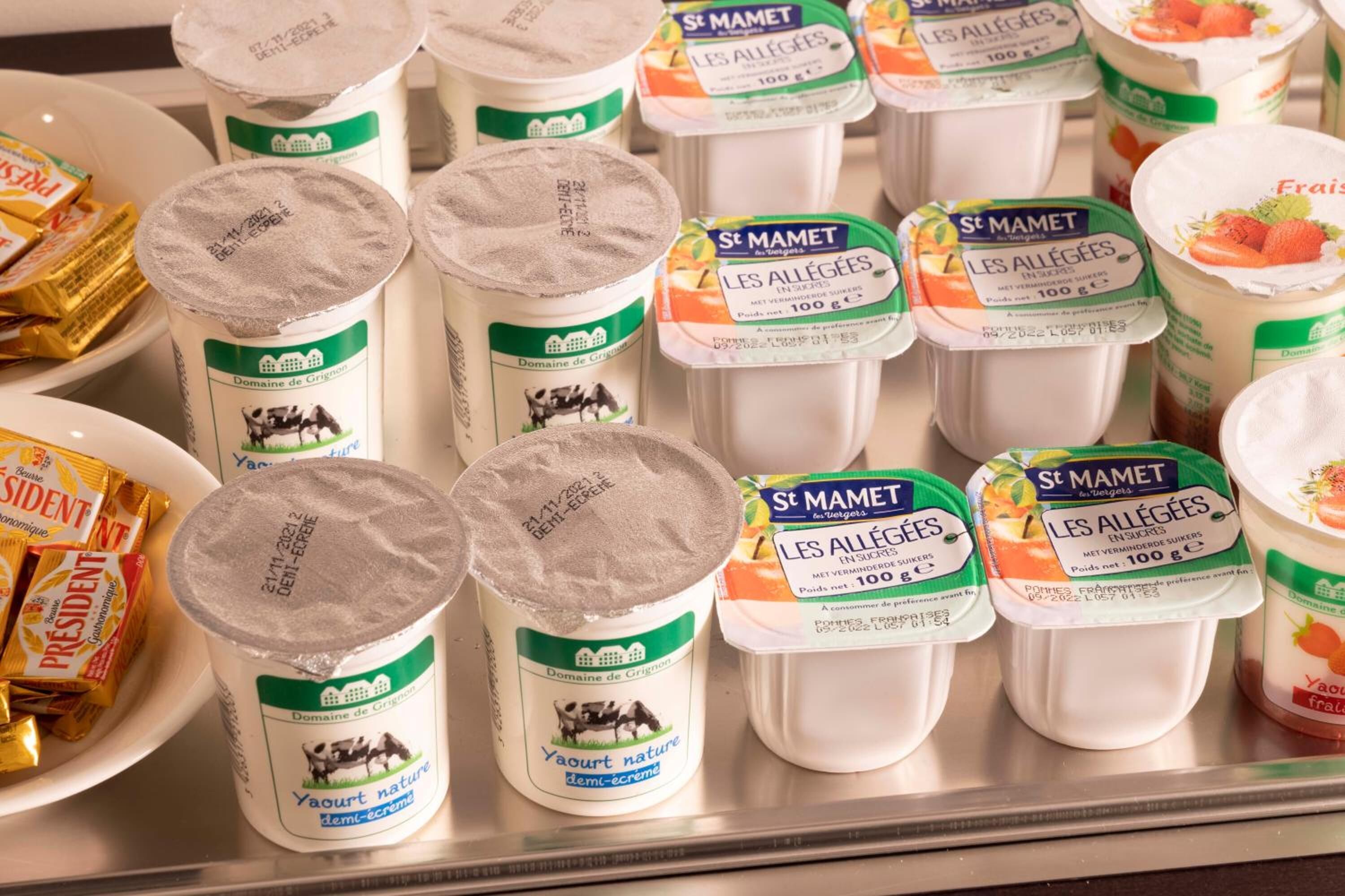 Variedad de productos lácteos, incluyendo yogur y queso, en un refrigerador.