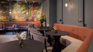 A modern interior with a mural, seating areas, and tables. - Grand Hotel Leveque (Paris)