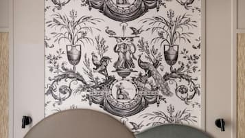 Une pièce ornée d’une grande tapisserie richement décorée, représentant des motifs botaniques et mythologiques.
