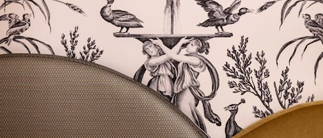 Primer plano de un papel tapiz con una detallada ilustración en blanco y negro de aves y follaje.