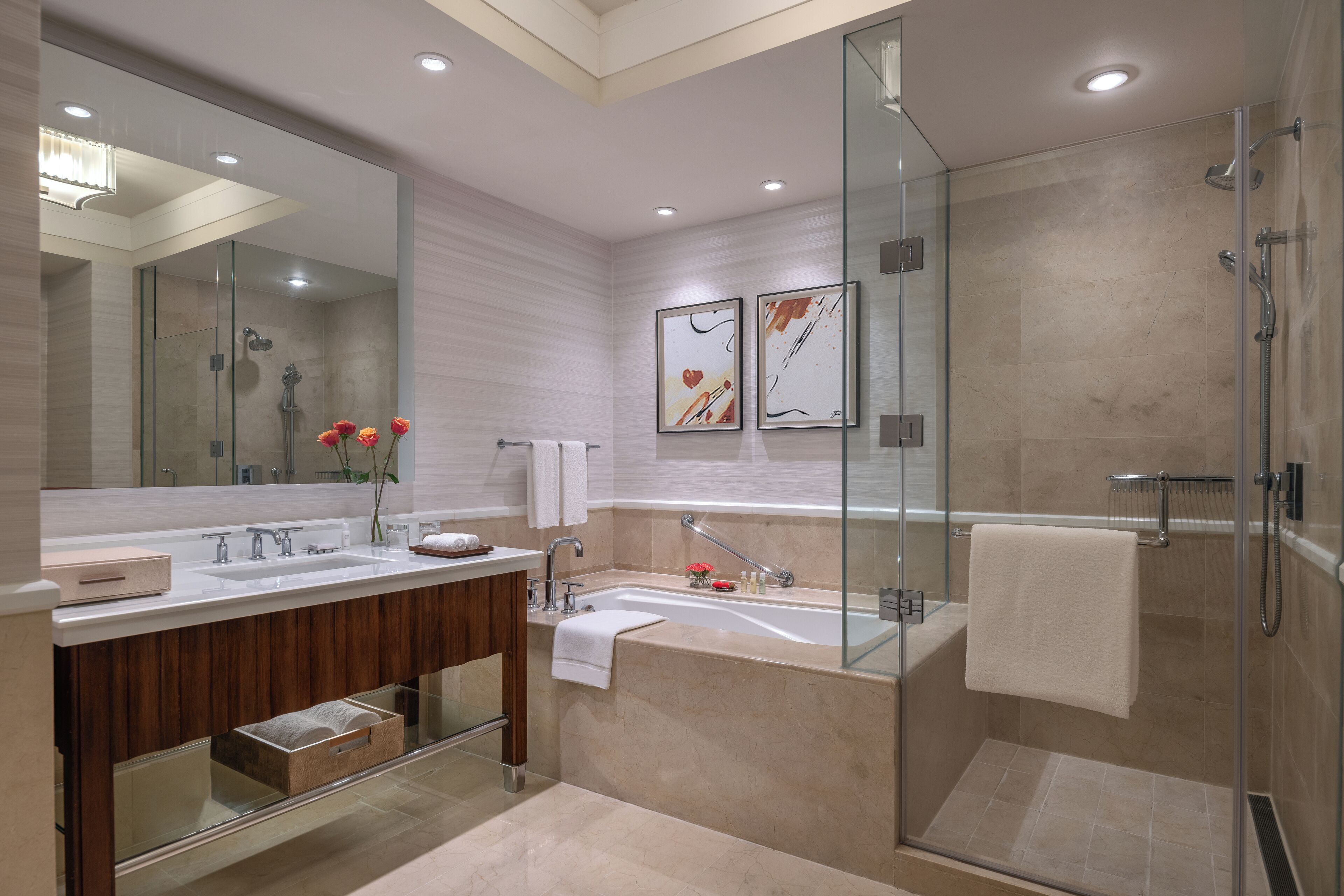 Un baño moderno con cabina de ducha de vidrio, tocador doble y un espejo grande.