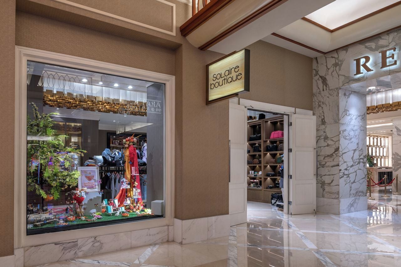 A boutique with a large display window, marble flooring, and a sign for 'solaire boutique'.