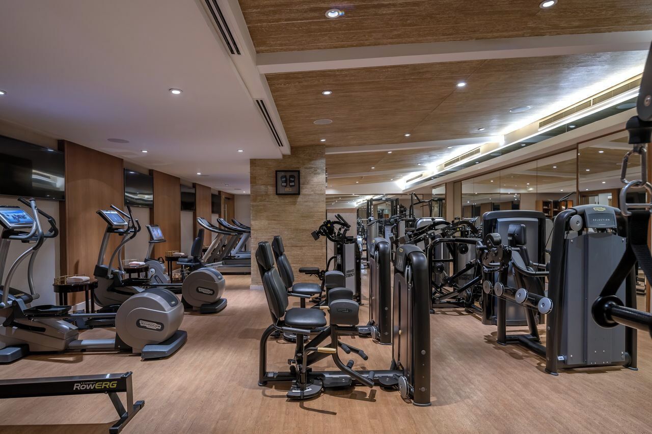 Ein Fitnessstudio mit Laufbändern, Crosstrainern und Gewichten.