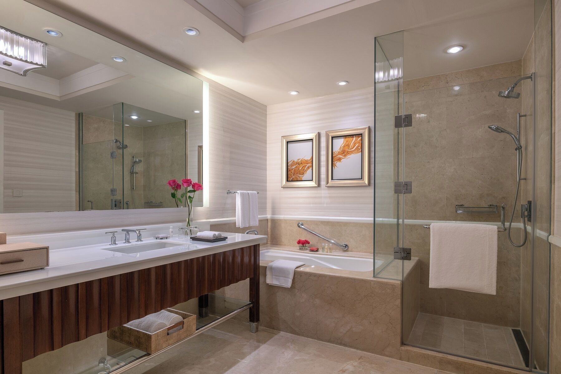 Un baño moderno con ducha de vidrio, tocador doble y un espejo grande.