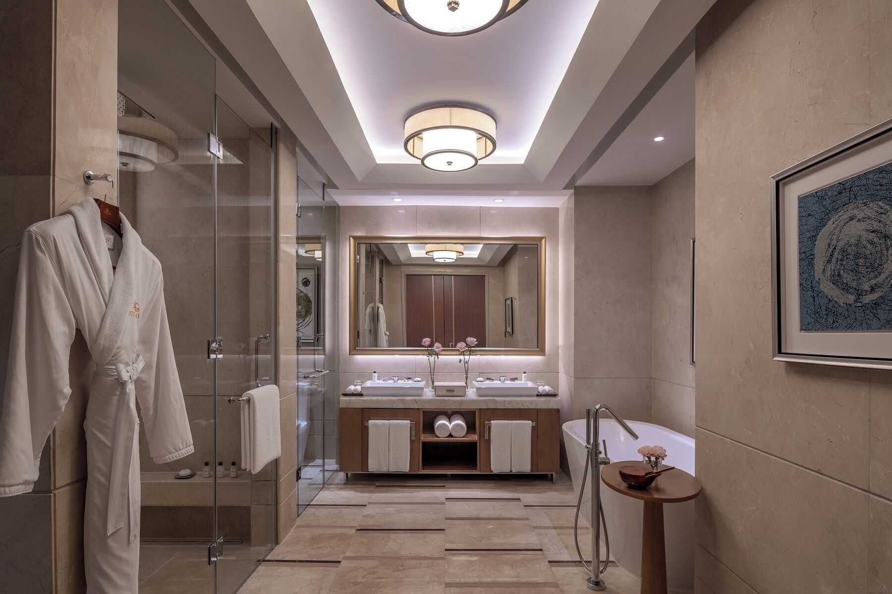 A modern bathroom with a glass shower enclosure, a double sink vanity, and a large mirror.