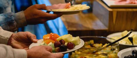A buffet with various dishes including fruits, vegetables, and a casserole.