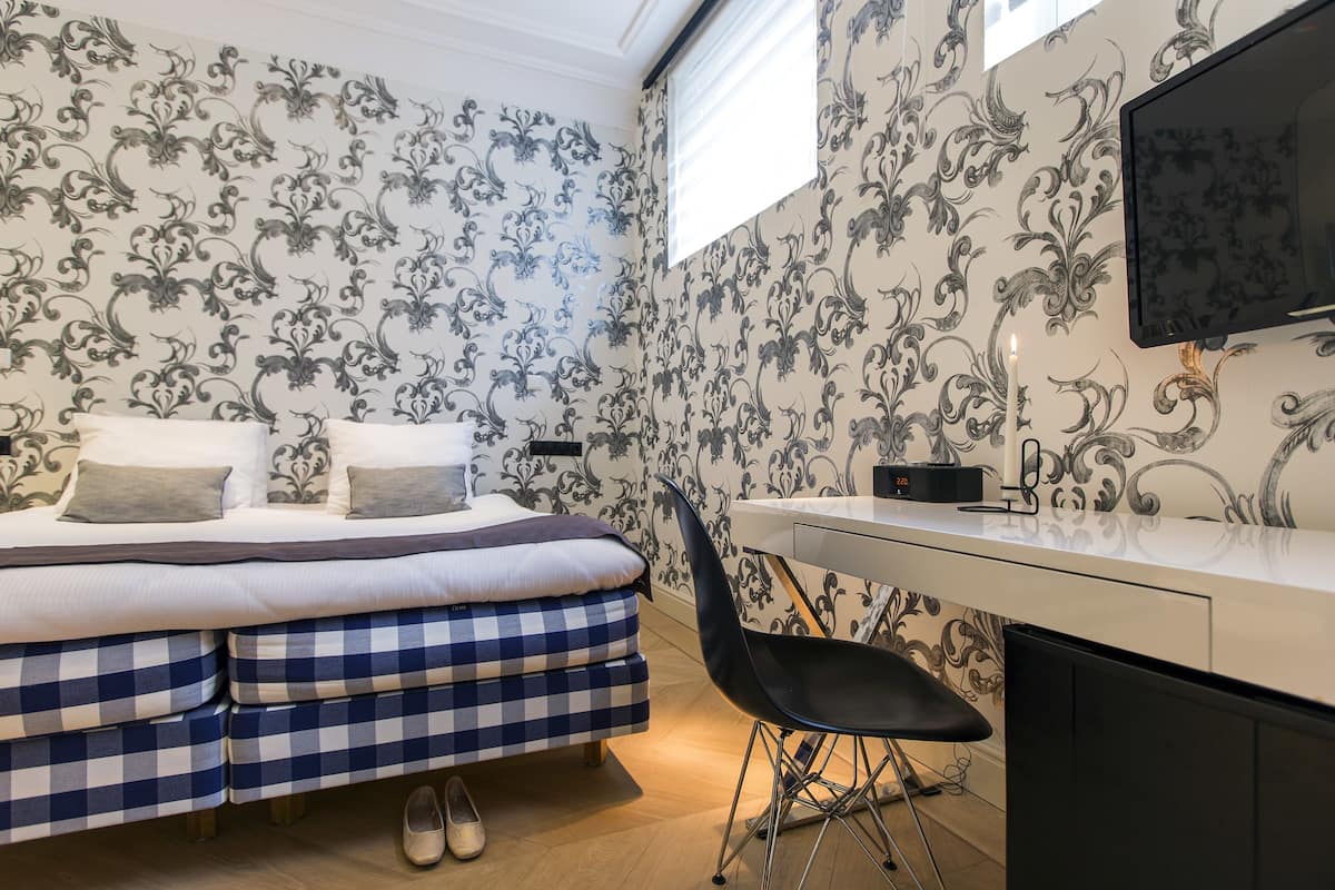 Une chambre à coucher avec un lit, un bureau, une chaise et un téléviseur.