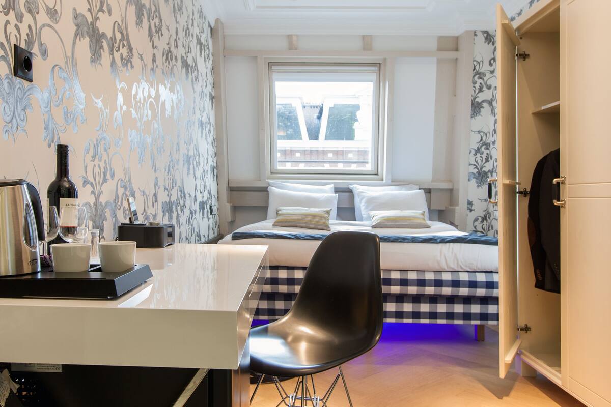 Une chambre à coucher comprenant un lit, un bureau, une chaise et une armoire.