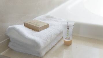 A white towel and a bath gel tube on a bathroom counter.