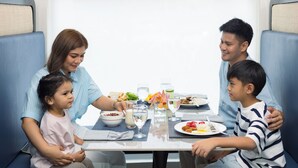 Una familia cenando en una mesa con vistas a la ventana.