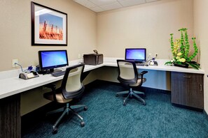 A workspace with two desks, chairs, computers, a printer, and a decorative plant. - Candlewood Suites Manhattan by IHG (Manhattan)