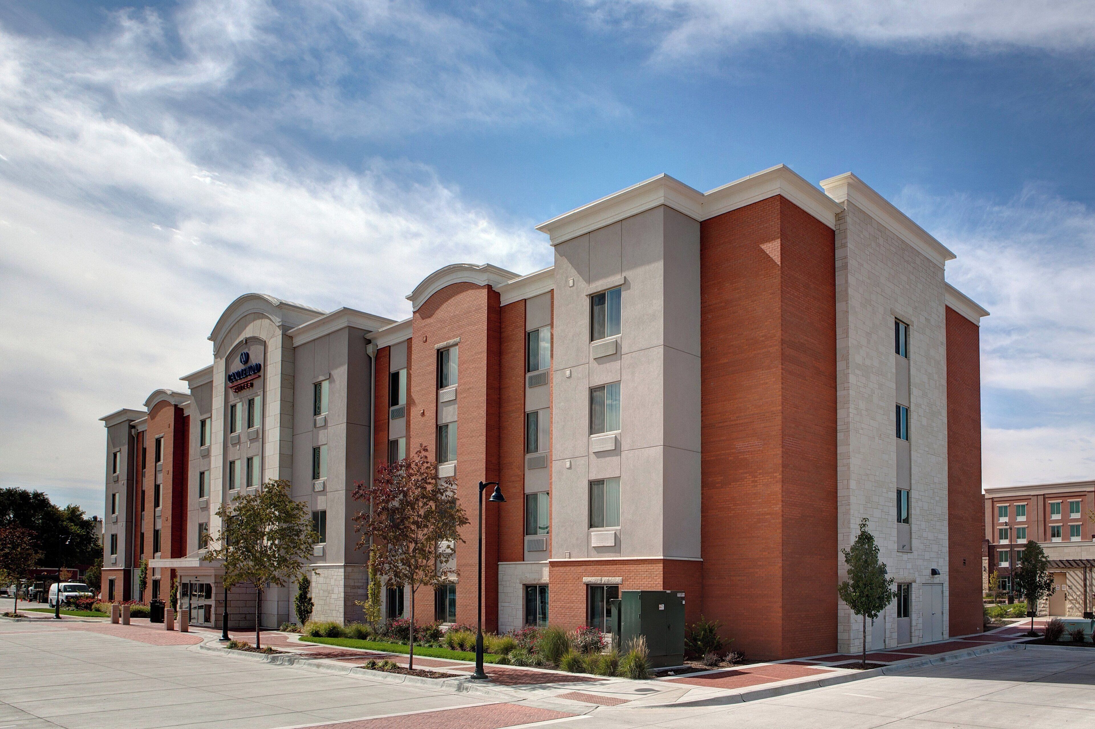 A multi-story hotel with a brick facade, large windows, and a flat roof.