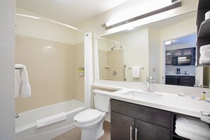 Een moderne badkamer met een bad, toilet en wastafel.