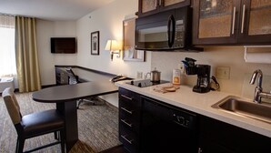 Eine kleine Hotelküche mit Mikrowelle, Kaffeemaschine und Spüle.