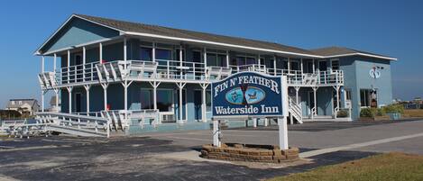 A large, multi-story building with a sign reading "Fin' N' Feather Waterside Inn."