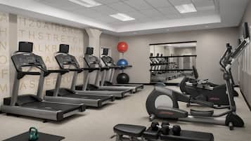 A gym with treadmills, elliptical machines, and free weights.