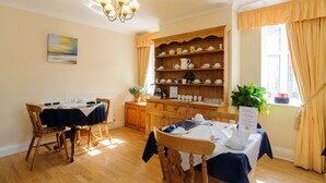 A dining area with a wooden buffet and a chandelier. - The Gables Guest House (Lincoln)