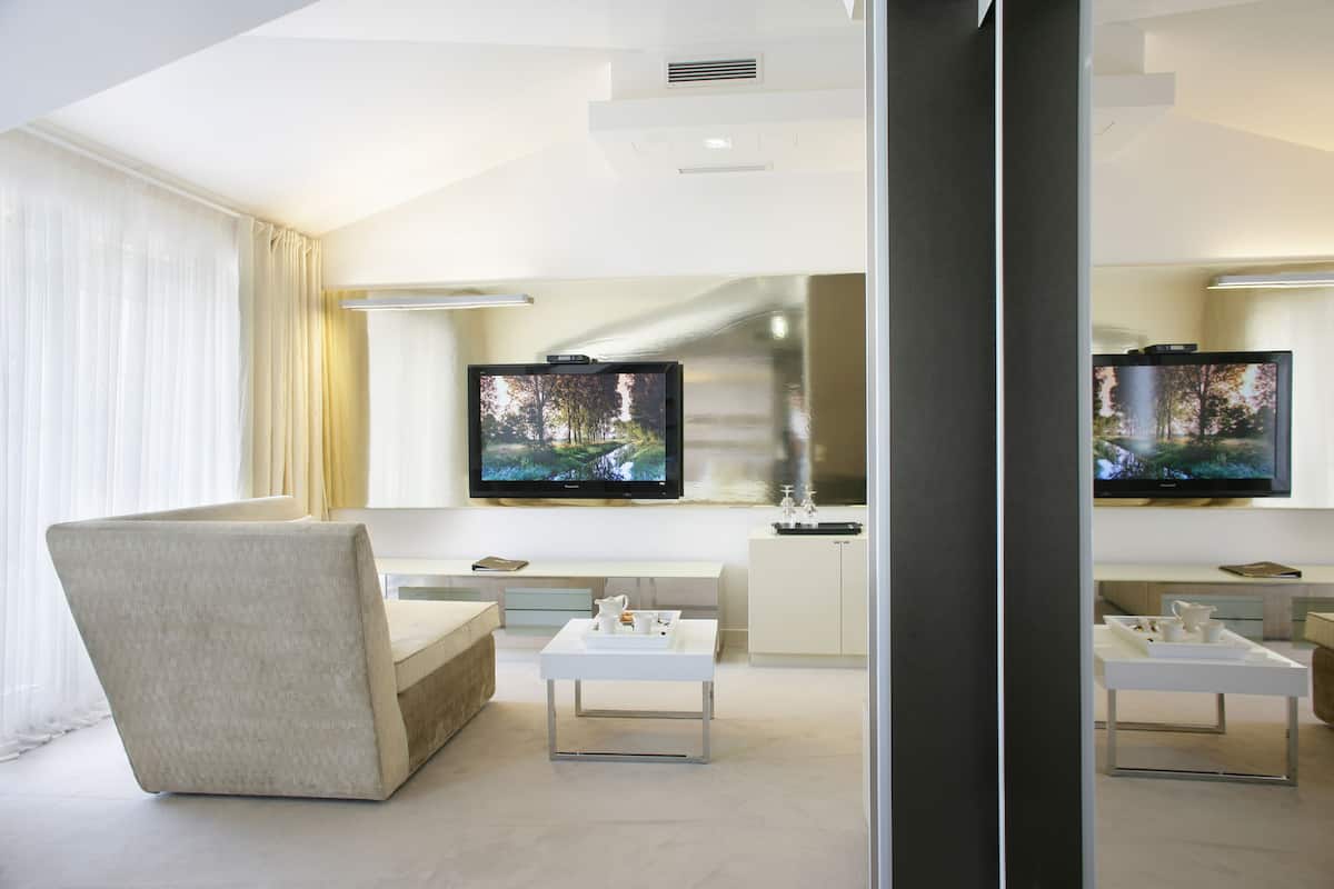 Een moderne woonkamer met een bank, een salontafel en een flatscreen televisie aan de muur.