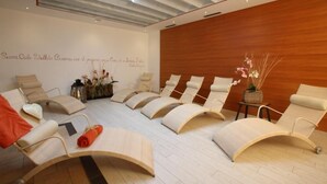 A modern spa room with reclining chairs, a wooden wall, and a ceiling with a unique design. - Hotel Majorka (Andalo)