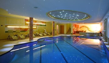 Una piscina techada, sillones reclinables de piscina