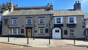 A traditional building with a sign for "The Three Horseshoes Hotel".