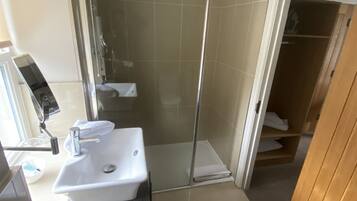 Une salle de bain moderne avec une douche, un lavabo et un miroir.