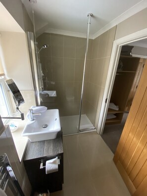 A modern bathroom with a shower, sink, and mirror. - The Three Horseshoes Hotel (Barnard Castle)