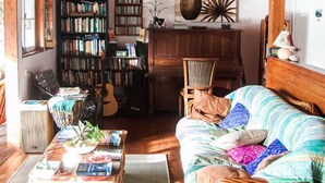 A cozy living room with a wooden ceiling, a bookshelf, a dining table, and a comfortable sofa. - The Epiphyte Bed & Breakfast (Cow Bay)