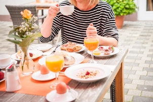 A breakfast table with various dishes, a cup, and a glass of orange juice.
