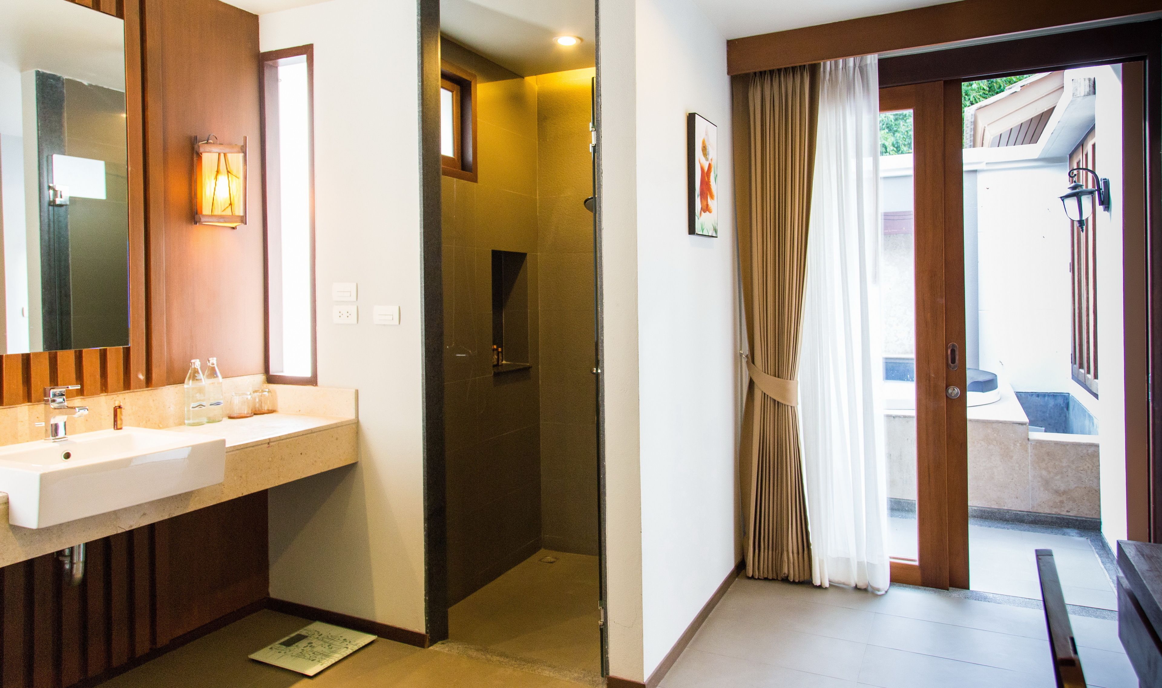 A bathroom with a sink, mirror, and shower.