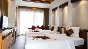 A hotel room with two beds, a desk, and a television. - Maehaad Bay Resort (Ko Pha-ngan)