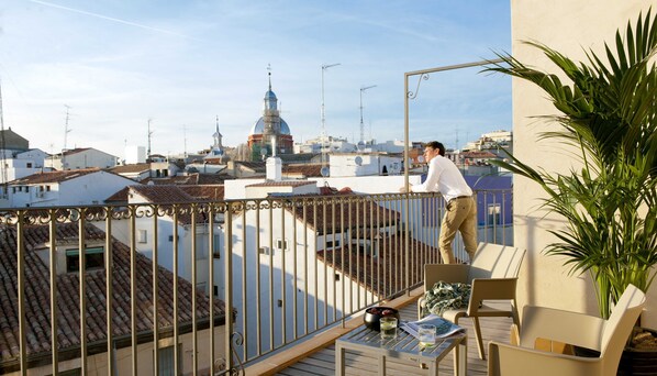 A balcony with a view of a cityscape, including a prominent dome building.