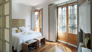 Ein Schlafzimmer mit Bett, Nachttisch und einem Fenster mit Blick.