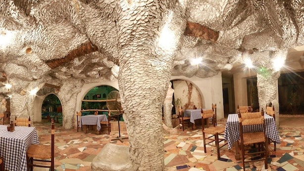 Een interieur met stenen muren en tafels klaar voor het diner.
