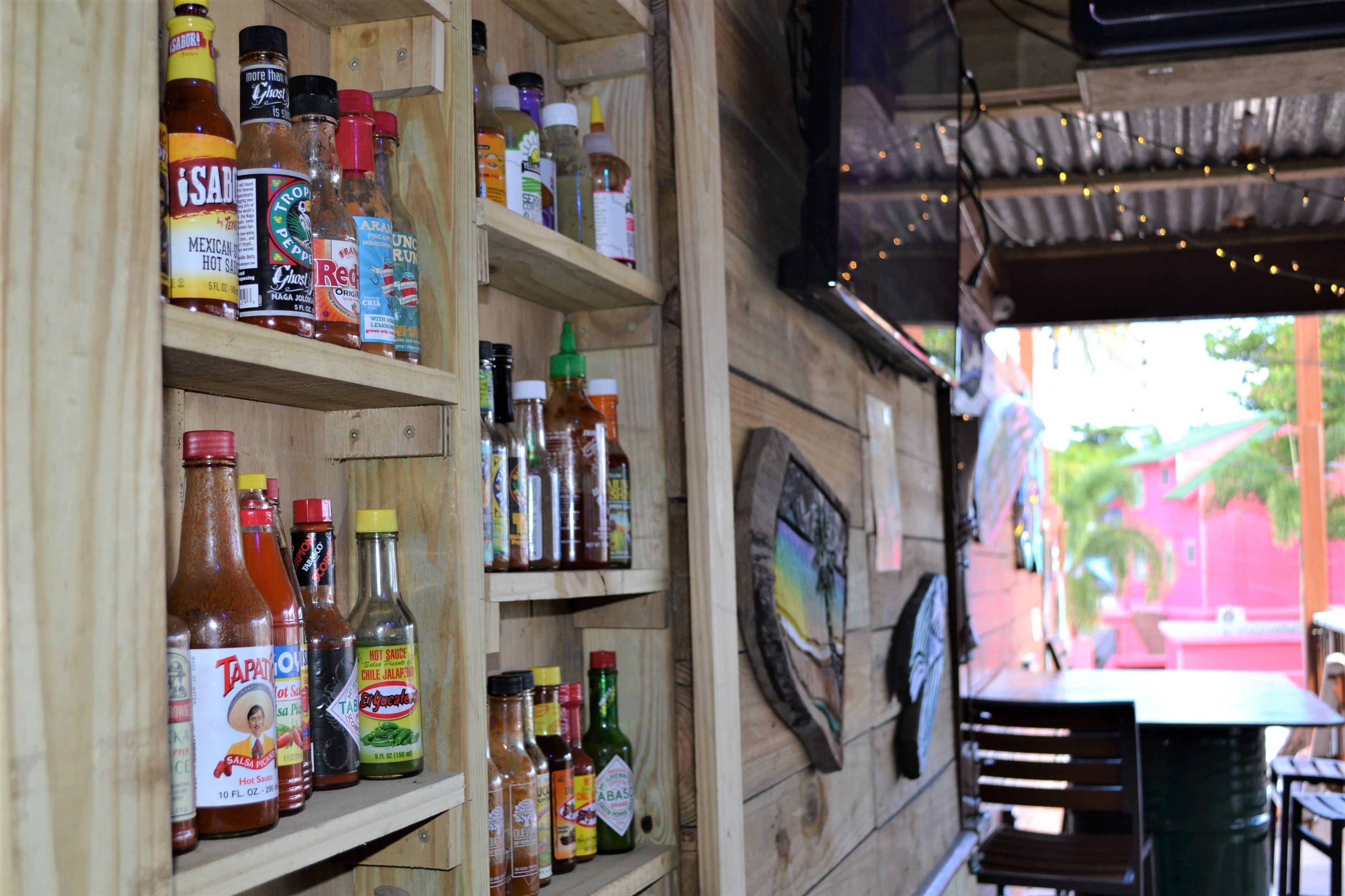 Une étagère en bois sur laquelle sont disposés divers condiments et sauces.