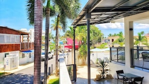 A covered outdoor area with a patio, seating, and a view of the street. - Casa Verde Hotel - Steps to the Beach | Pool, Restaurant & Bar (Rincon)