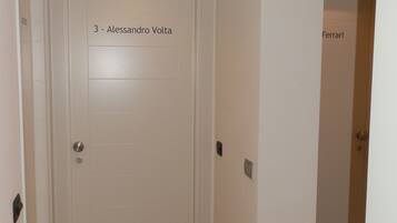 Un corridoio con una porta bianca con la scritta '3 - Alessandro Volta'.
