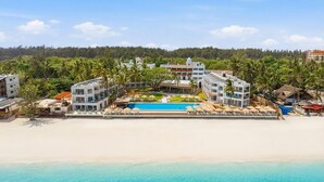 A resort with a swimming pool, beach, and palm trees. - Bamburi Beach Hotel - All Inclusive (Mombasa)