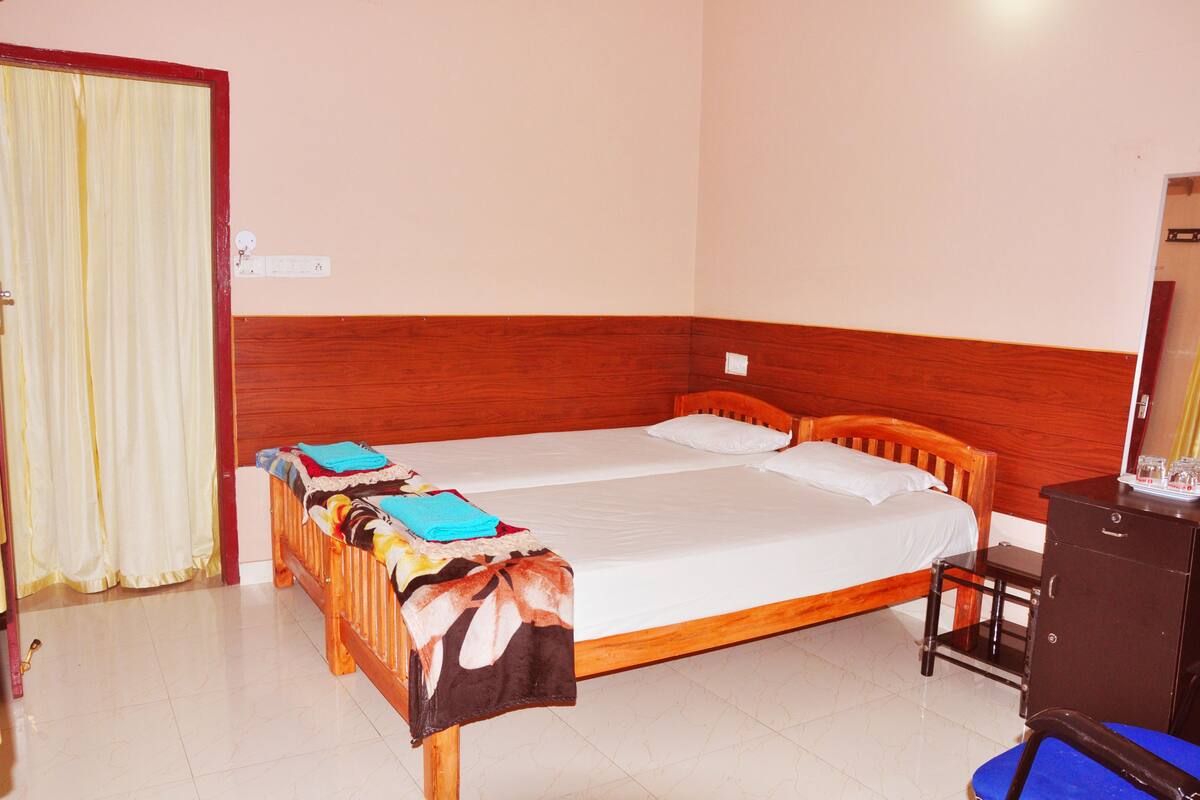 A double bed with a wooden headboard, a small bedside table, and a wardrobe.