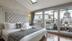 A modern hotel room with a large bed, a view of the city, and a balcony with outdoor furniture. - Louis Appartements Galata (Istanbul)