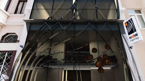 Un hôtel moderne, avec une façade en verre, de nombreux étages et une enseigne indiquant qu’il s’agit d’un hôtel.