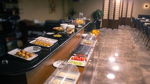Un buffet proposant une variété de plats et un espace où l’on peut s’asseoir, avec des chaises et des tables.