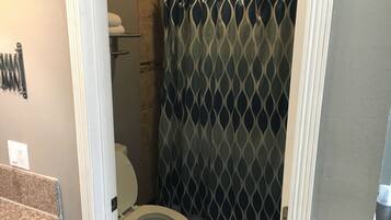 Un bagno piccolo con un WC, una tenda da doccia e un porta asciugamani.